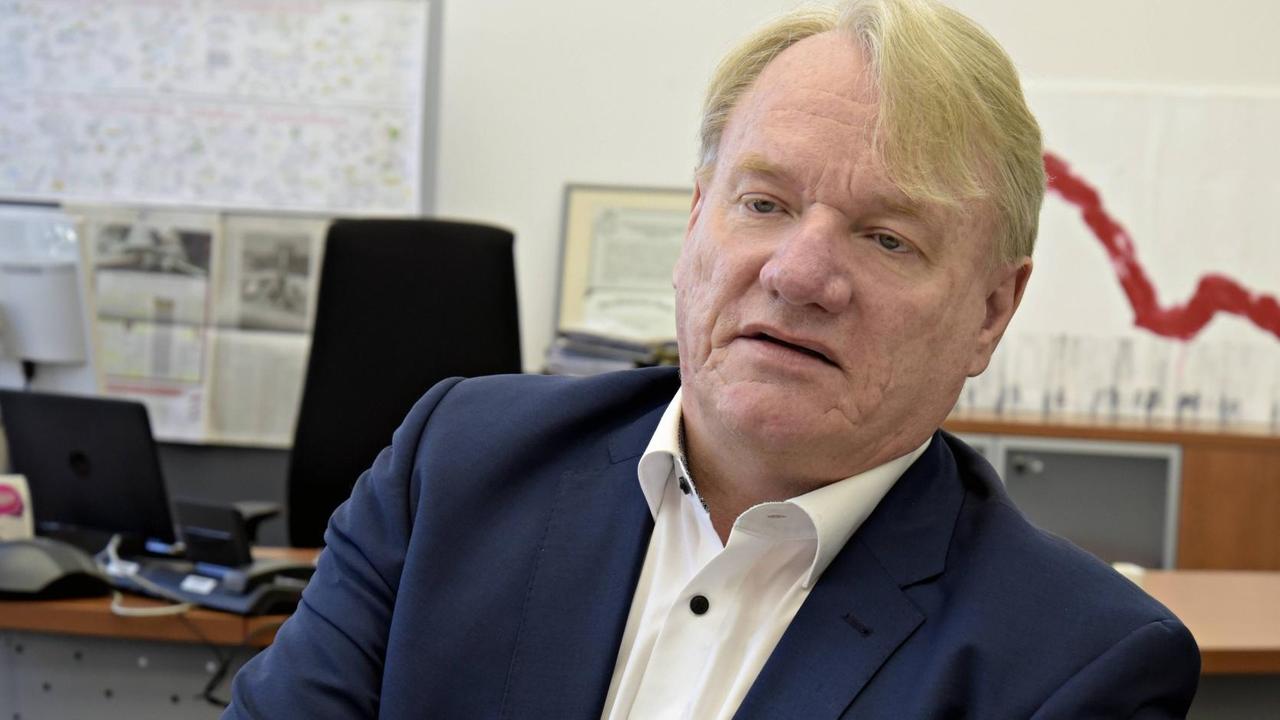 Bernd Becking, Chef der regionalen Arbeitsagentur, sitzt in seinem Büro in der Arbeitsagentur, Friedrichstraße. Im Hintergrund ist ein Diagramm zu sehen, bei dem eine rote Linie steil nach unten verläuft. Bernd Becking, Chef der regionalen Arbeitsagentur, sitzt in seinem Büro in der Arbeitsagentur, Friedrichstraße. Im Hintergrund ist ein Diagramm zu sehen, bei dem eine rote Linie steil nach unten verläuft.