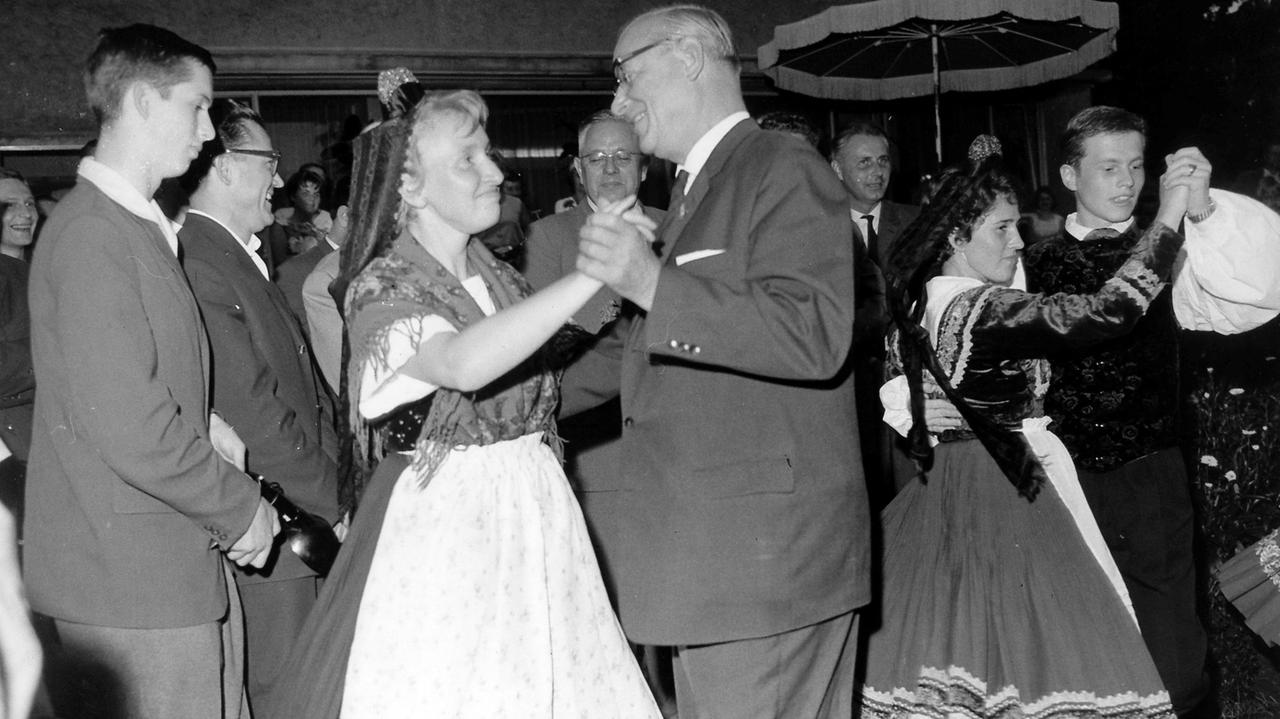 Hessens Ministerpräsident  Georg August Zinn (M) wagt ein Tänzchen mit einer jungen Frau in hessischer Tracht. Der erste Hessentag fand am 1. Juli 1961 in Alsfeld statt.