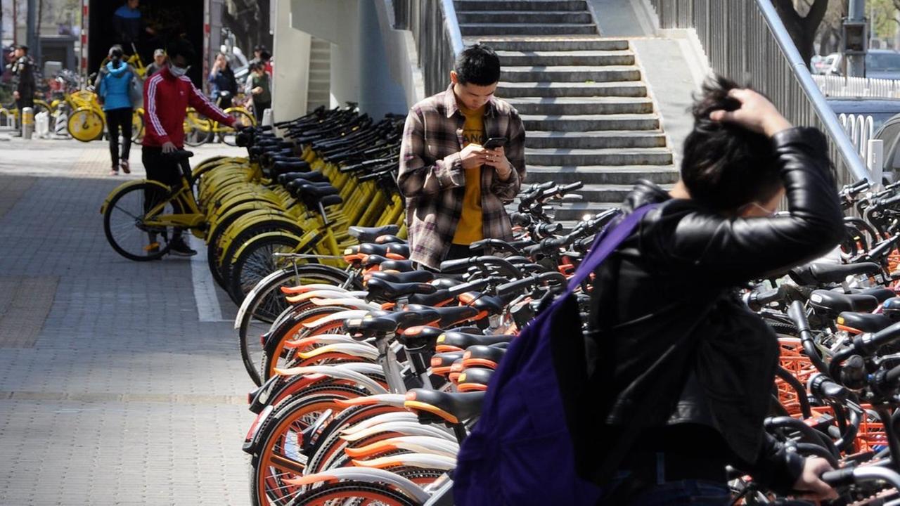 Leihräder stehen aneinander gereiht auf einem Fußweg. Das Geschäft mit den Mieträdern in China boomt. Leihräder stehen aneinander gereiht auf einem Fußweg. Das Geschäft mit den Mieträdern in China boomt.