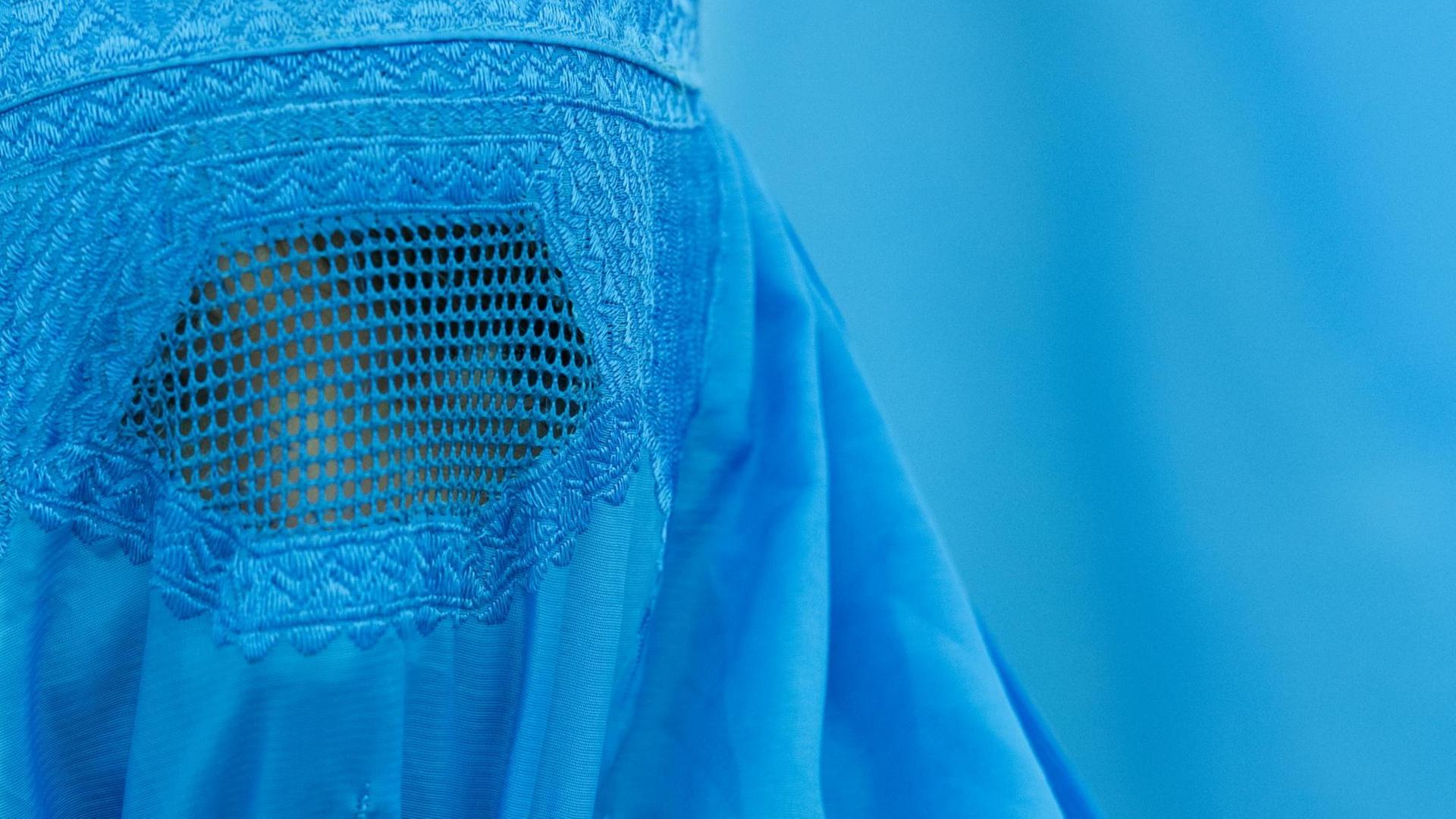 Hellblauer Burka vor hellblauem Hintergrund. Hellblauer Burka vor hellblauem Hintergrund.