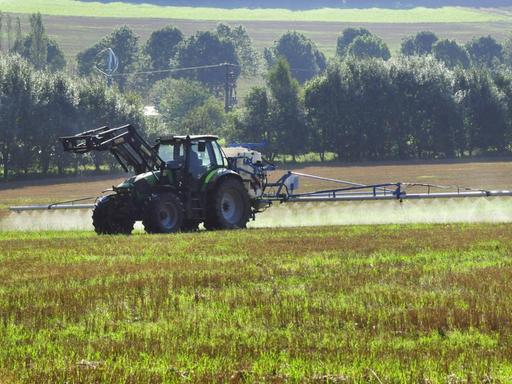  Traktor spritzt Glyphosat zur Unkrautvernichtung im Sommer auf einem Acker in Rheinland-Pfalz.
