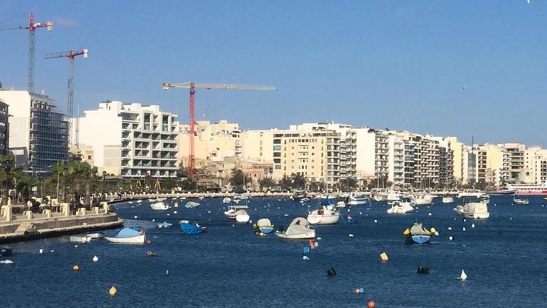 Baukräne und Gebäude im Übergang zwischen den Städten Gzira und Sliema auf Malta in der Nähe von Valletta