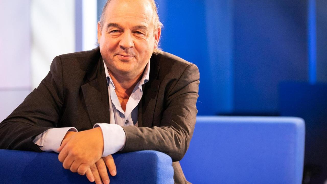 Porträt von Karl-Heinz Ott auf dem blauen Sofa zur frankfurter Buchmesse. Porträt von Karl-Heinz Ott auf dem blauen Sofa zur frankfurter Buchmesse.