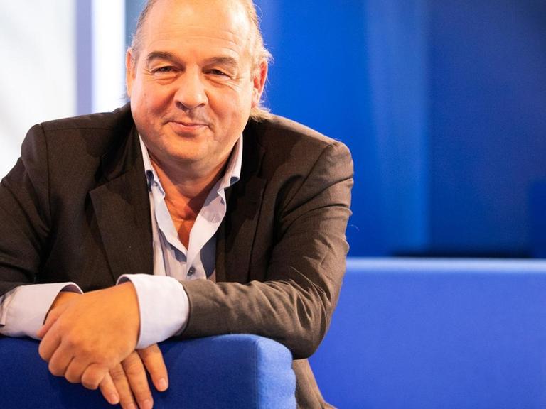 Porträt von Karl-Heinz Ott auf dem blauen Sofa zur frankfurter Buchmesse.