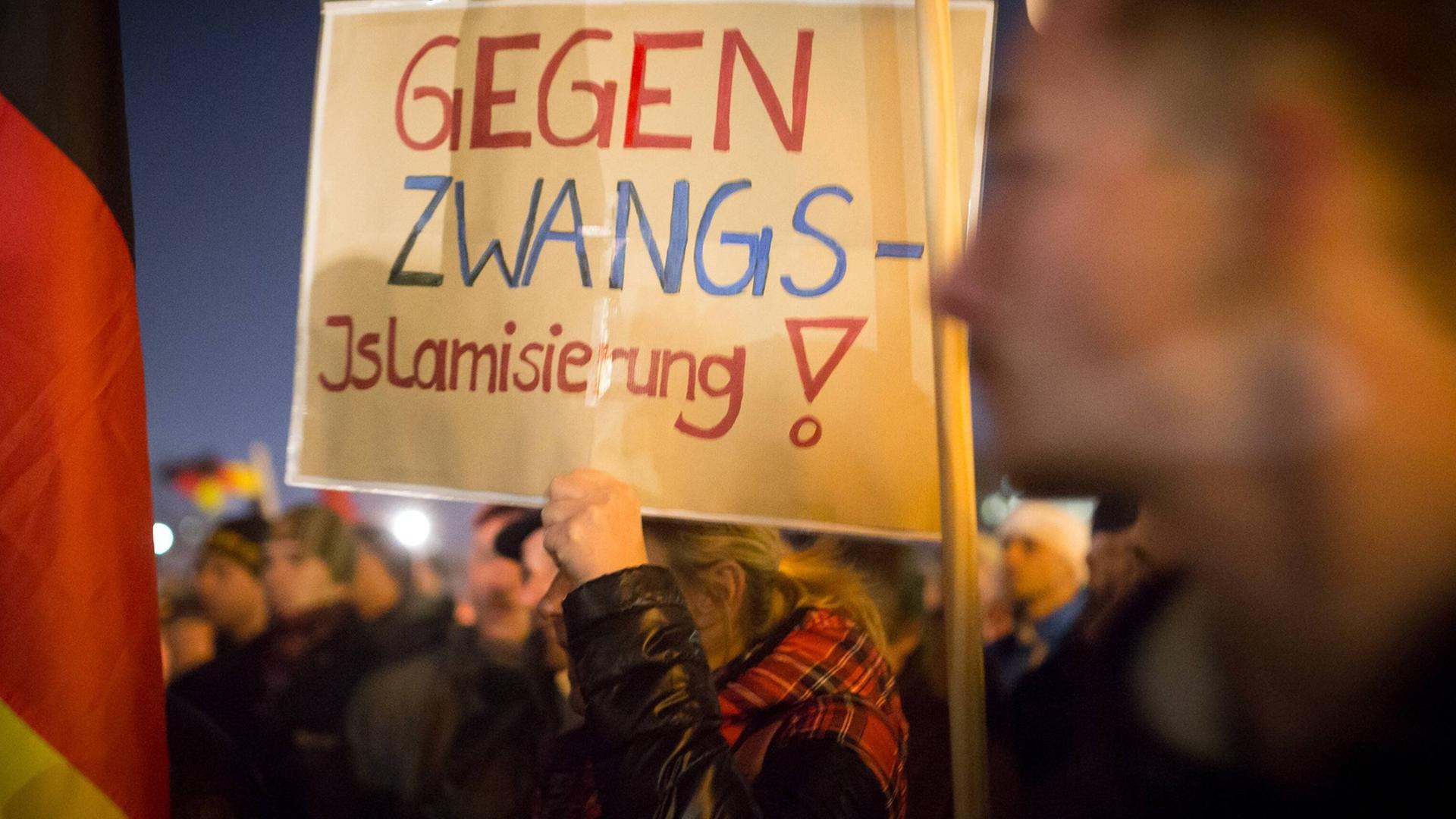 Eine Frau, die sich offenbar vor einer "Zwangs-Islamisierung" fürchtet, demonstriert bei einer "PEGIDA"-Kundgebung Eine Frau, die sich offenbar vor einer "Zwangs-Islamisierung" fürchtet, demonstriert bei einer "PEGIDA"-Kundgebung