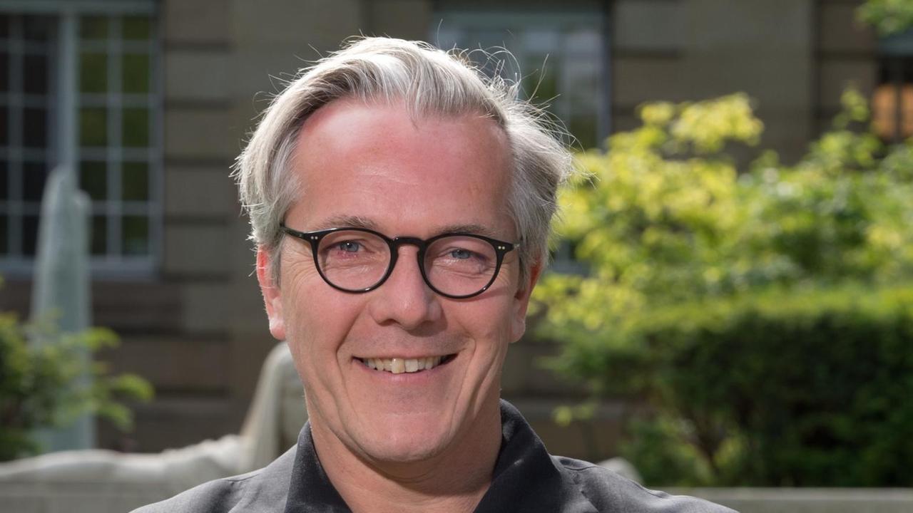 Marc-Oliver Hendriks, der geschäftsführende Intendant des Dreispartenhauses Staatstheater Stuttgart, blickt freundlich lächelnd in Richtung Betrachter. Marc-Oliver Hendriks, der geschäftsführende Intendant des Dreispartenhauses Staatstheater Stuttgart, blickt freundlich lächelnd in Richtung Betrachter.