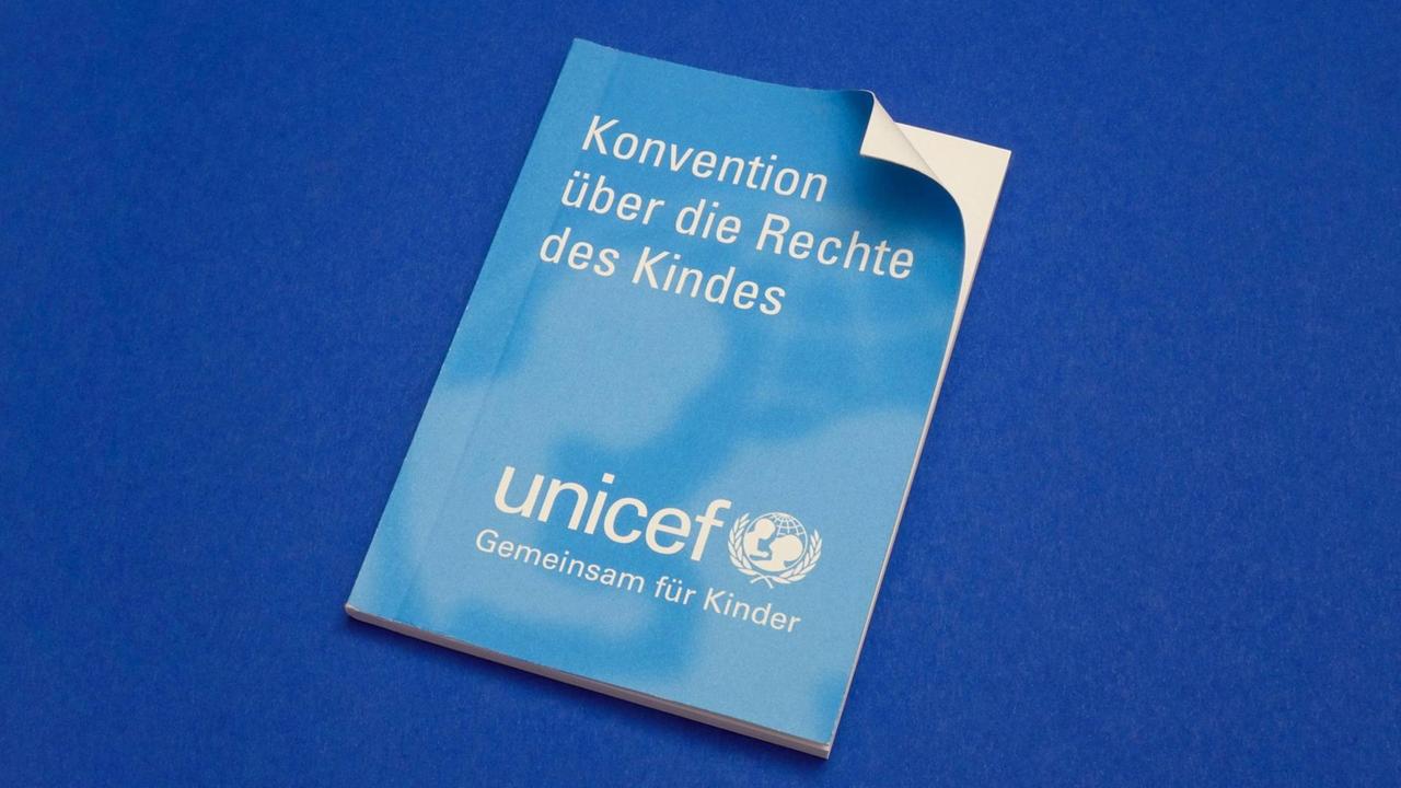 Eine Konvention über die Rechte des Kindes von Unicef liegt auf einem blauen Untergrund.