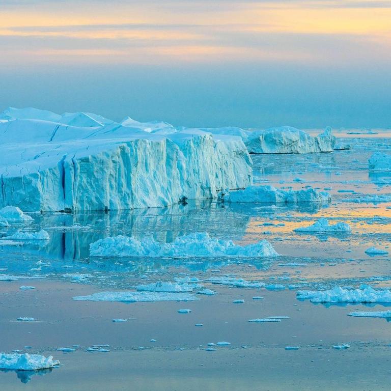 Das Bild zeigt Eisberge in Grönländ während der Dämmerung