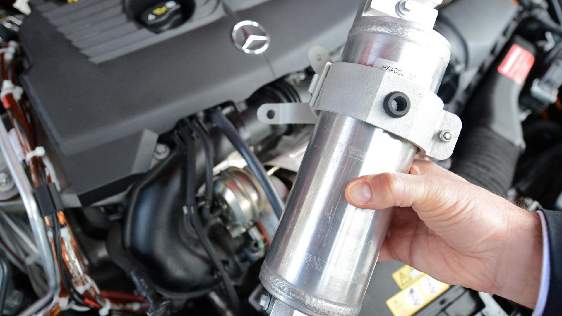 Interner Wärmetauscher einer CO2-Klimanalage wird vor den Motor eines Erprobungsfahrzeugs gehalten Interner Wärmetauscher einer CO2-Klimanalage wird vor den Motor eines Erprobungsfahrzeugs gehalten