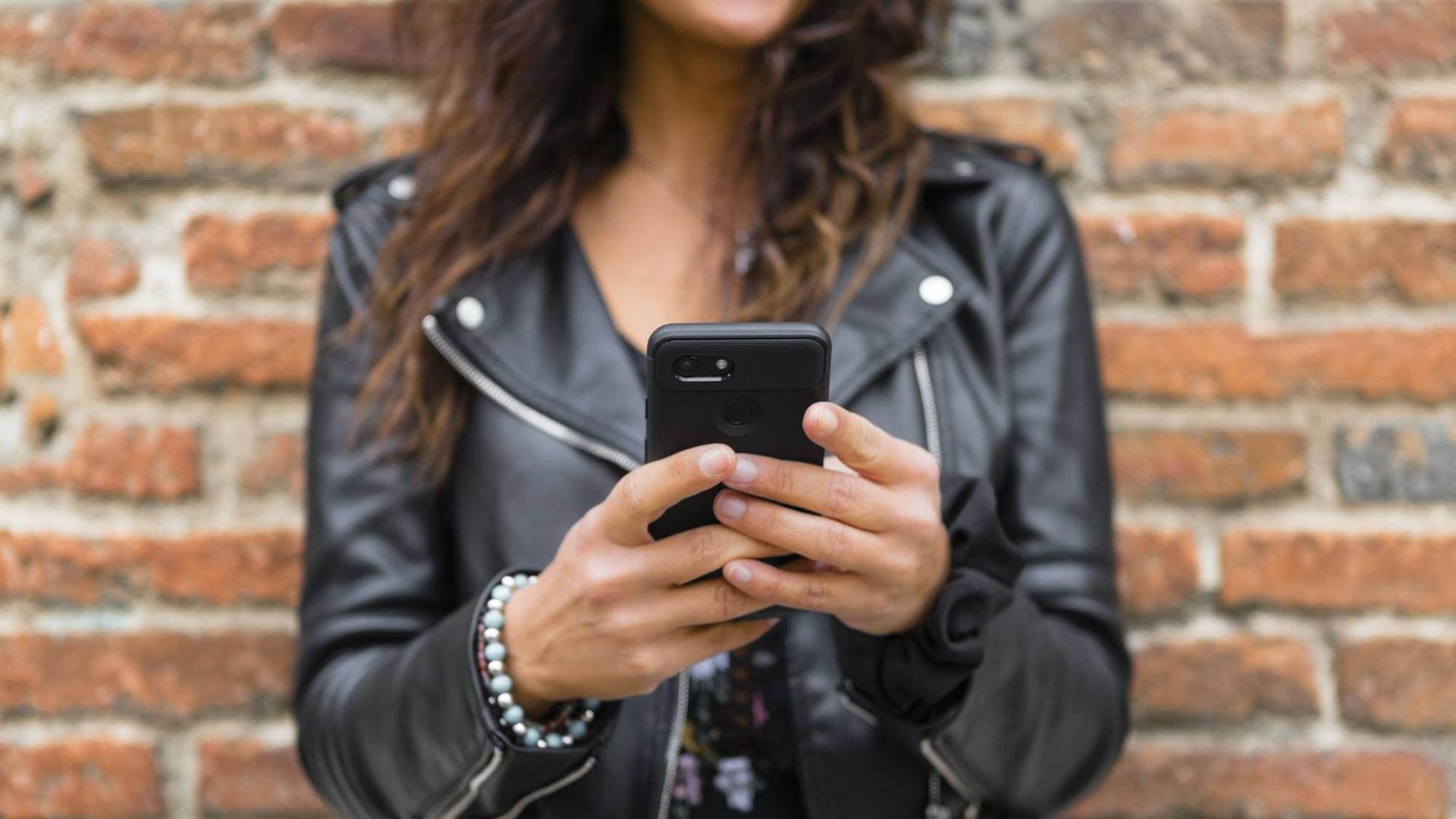 Ein Frau hält ein Handy in der Hand. Ein Frau hält ein Handy in der Hand.