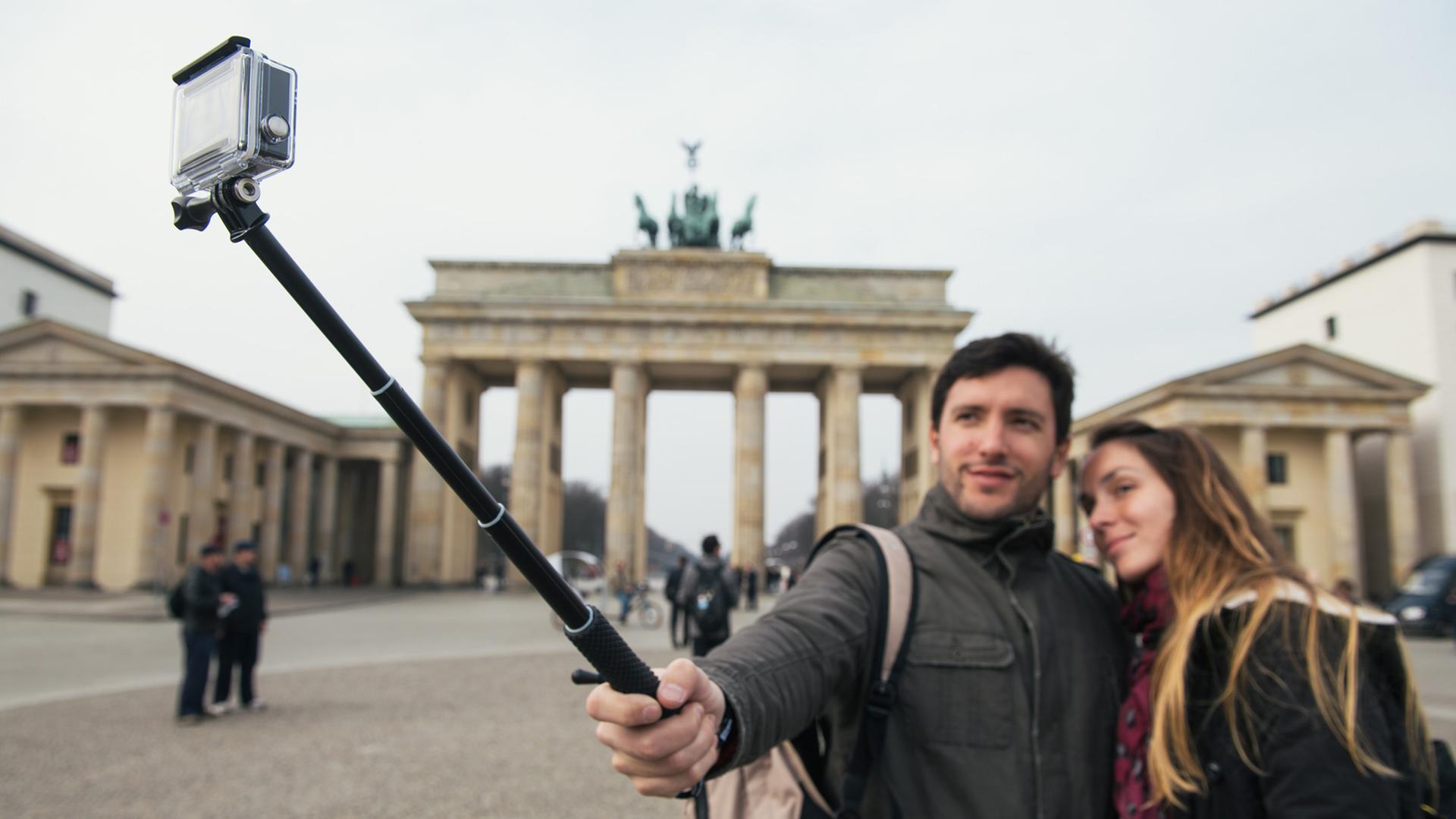 Zwei italienische Touristen machen am am Brandenburger Tor in Berlin ein Selbstporträt mit einem "Selfie-Stick". Zwei italienische Touristen machen am am Brandenburger Tor in Berlin ein Selbstporträt mit einem "Selfie-Stick".
