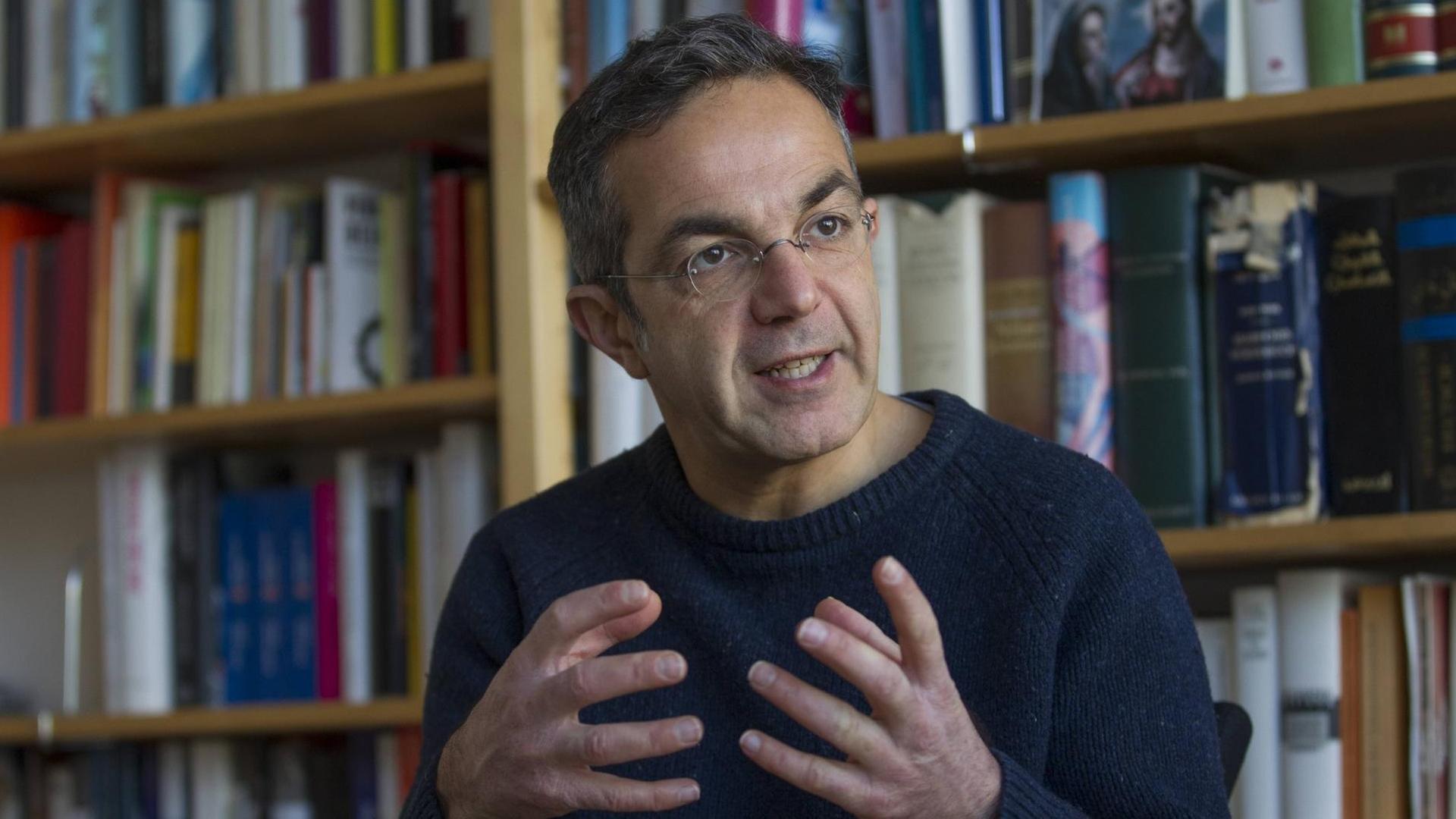 Der Schriftsteller Navid Kermani Schriftsteller gestikuliert im Februar 2018 vor einem Bücherregal. Der Schriftsteller Navid Kermani Schriftsteller gestikuliert im Februar 2018 vor einem Bücherregal.