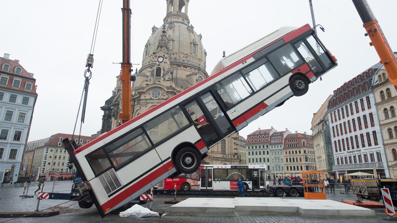 Ein Linienbus wird am 6.2.2017 auf dem Neumarkt vor der Frauenkirche in Dresden von einem Kran in eine senkrechte Position gehoben. Ein Linienbus wird am 6.2.2017 auf dem Neumarkt vor der Frauenkirche in Dresden von einem Kran in eine senkrechte Position gehoben.