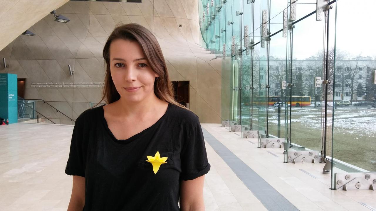 Maria Mossakowska im Gebäude des Museums POLIN, Museum für die Geschichte der polnischen Juden. Die gelbe Narzisse am T-Shirt symbolisiert den Aufstand im Warschauer Ghetto.