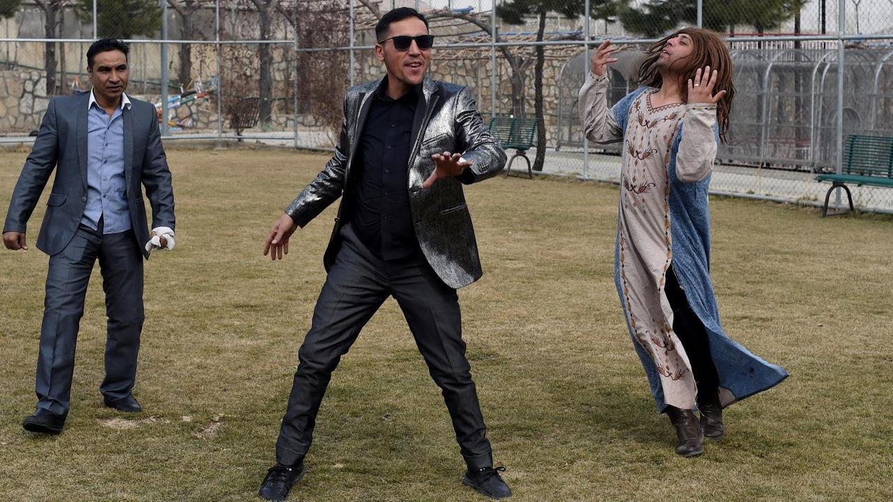 Die Comedian Ibrahim Abed, Gholam Nabi Roashan und Ahmad Siar Matin inszenieren sich überzogen auf einer Wiese. Die Comedian Ibrahim Abed, Gholam Nabi Roashan und Ahmad Siar Matin inszenieren sich überzogen auf einer Wiese.