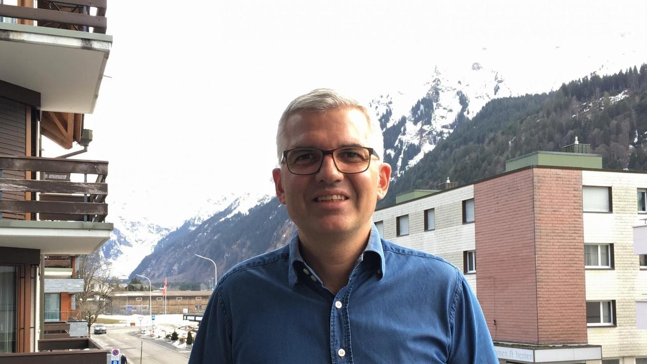 Frédéric Füssenich steht in Engelberg vor Wohnhäusern. Im Hintergrund sind schneebedeckte Berge zu sehen. Frédéric Füssenich steht in Engelberg vor Wohnhäusern. Im Hintergrund sind schneebedeckte Berge zu sehen.