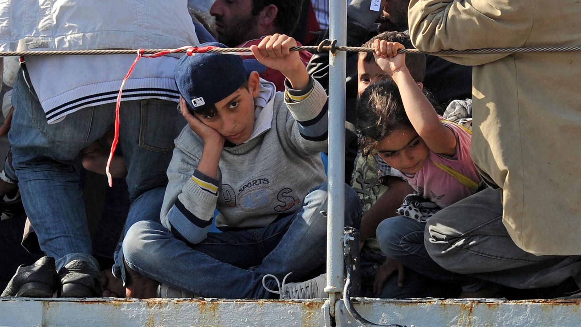 Flüchtlingskinder auf einem Boot bei der Ankunft in Sizilien. Flüchtlingskinder auf einem Boot bei der Ankunft in Sizilien.