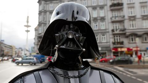 Ein Mitglied eines "Star Wars"-Fanclubs posiert in Hamburg in seinem Kostüm, das die Filmfigur Darth Vader darstellt.