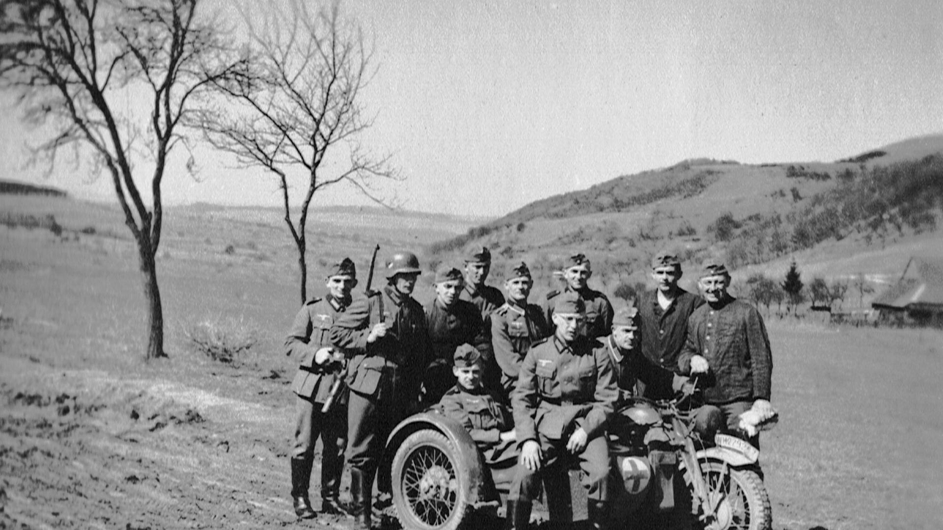 Kradfahrer und Soldaten haben sich zu einem Gruppenfoto in Frankreich aufgestellt - Herbst 1940.