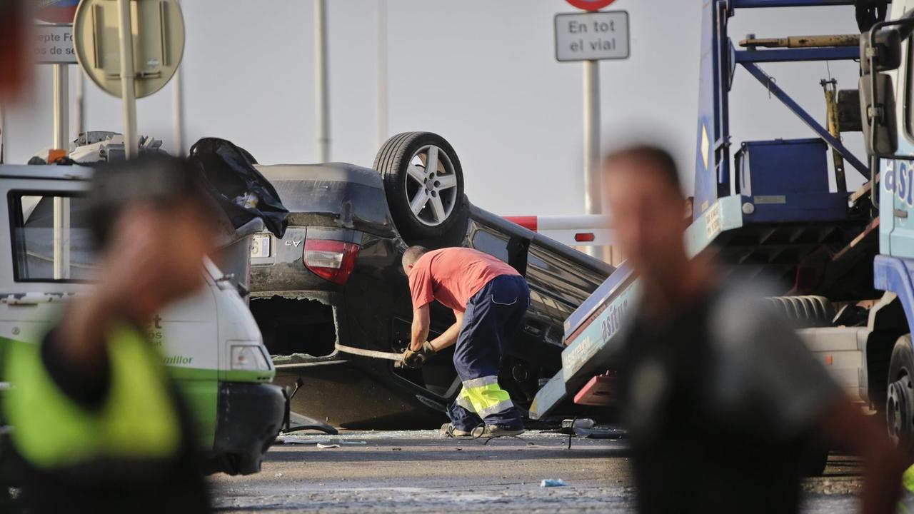 Ein Mann lädt am 18.08.2017 in Cambrils ein auf dem Dach liegendes Auto auf einen Abschleppwagen. Polizisten hatten dort zuvor fünf mutmaßliche Terroristen erschossen. Ein Mann lädt am 18.08.2017 in Cambrils ein auf dem Dach liegendes Auto auf einen Abschleppwagen. Polizisten hatten dort zuvor fünf mutmaßliche Terroristen erschossen.