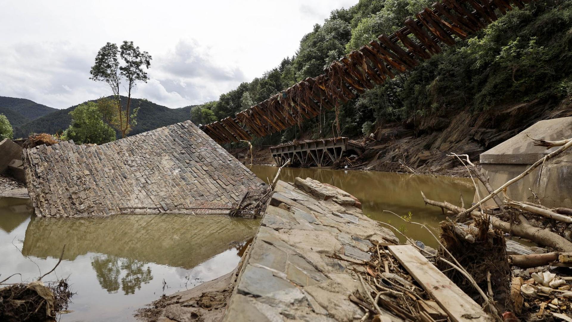 Nach dem Jahrhunderthochwasser in der Eifel durch heftige Regenfälle und Dauerregen mit Überschwemmungen und Überflutungen haben die Aufräumarbeiten im Ahrtal große Fortschritte gemacht. Einheiten von Polizei, THW, Bundeswehr und Feuerwehr mitsamt vielen freiwilligen Helfern haben Straßen geräumt, Schutt und Schlamm entfernt und die Menschen versorgt. Der Wiederaufbau wird trotzdem Jahre dauern. Im Bild Flutschäden an einer Brücke zwischen Rech und Mayschoß. Nach dem Jahrhunderthochwasser in der Eifel durch heftige Regenfälle und Dauerregen mit Überschwemmungen und Überflutungen haben die Aufräumarbeiten im Ahrtal große Fortschritte gemacht. Einheiten von Polizei, THW, Bundeswehr und Feuerwehr mitsamt vielen freiwilligen Helfern haben Straßen geräumt, Schutt und Schlamm entfernt und die Menschen versorgt. Der Wiederaufbau wird trotzdem Jahre dauern. Im Bild Flutschäden an einer Brücke zwischen Rech und Mayschoß.
