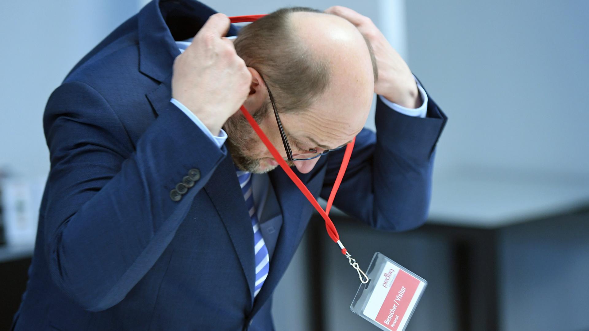 Der SPD-Kanzlerkandidat Martin Schulz hängt sich im Unternehmen "Pedag International" in Königs Wusterhausen in Brandenburg ein Besucherschild um. Der SPD-Kanzlerkandidat Martin Schulz hängt sich im Unternehmen "Pedag International" in Königs Wusterhausen in Brandenburg ein Besucherschild um.