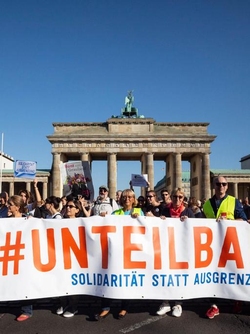 13.10.2018, Berlin: Der Zug der Demonstration gegen Rassismus und Rechtsruck mit dem Motto «Unteilbar» zieht vor das Brandenburger Tor