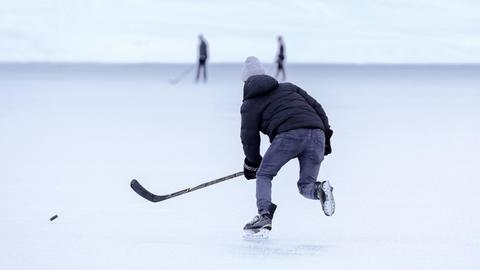 Pondhockey-Spieler auf dem zugefrorenen Oeschinensee in der Schweiz.