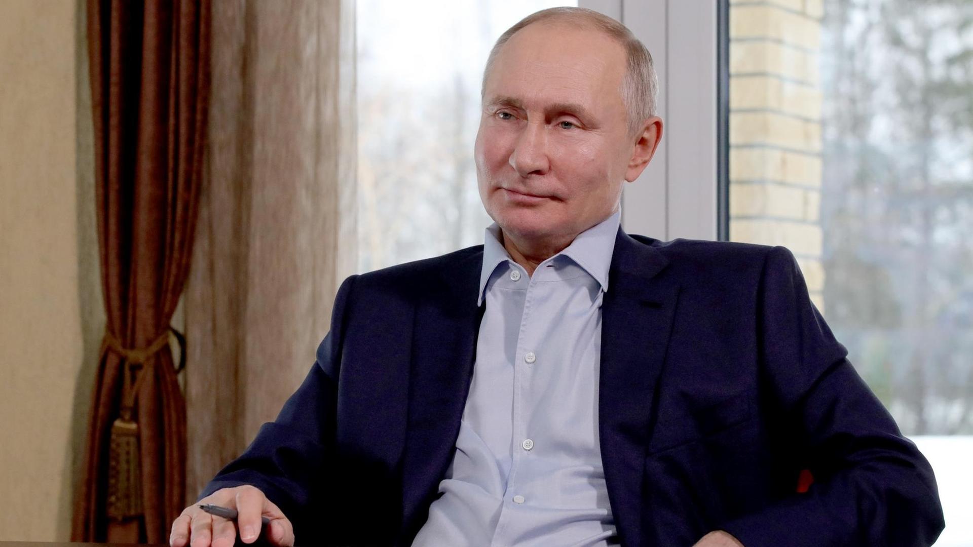 Wladimir Putin, Präsident von dem Land Russland, sitzt in einem Stuhl. Wladimir Putin, Präsident von dem Land Russland, sitzt in einem Stuhl.