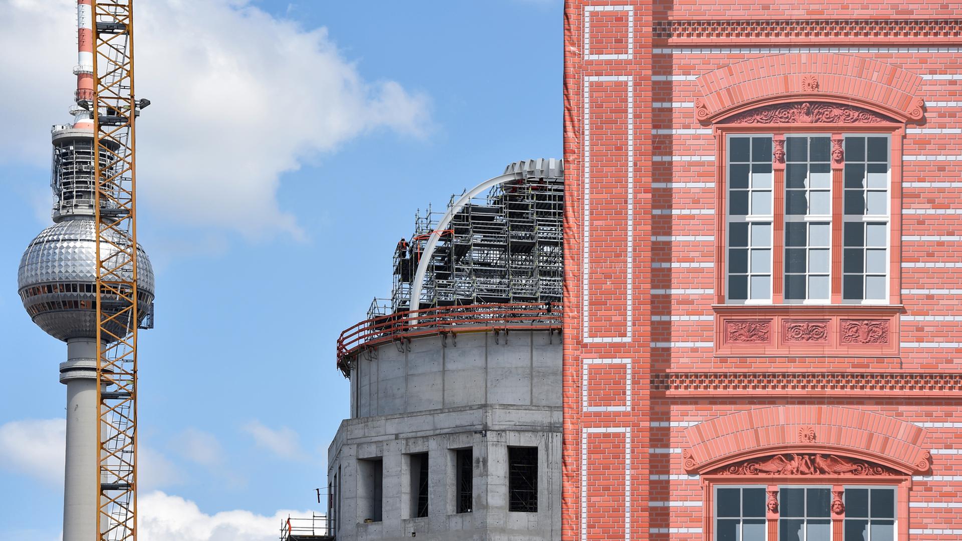 Die Kuppel des Rohbaus des Berliner Schlosses (l), das den Namen Humboldt-Forum trägt, ist am 09.06.2015 in Berlin am Schinkelplatz neben der Schaufassade der Schinkelschen Bauakademie zu sehen. Die Kuppel des Rohbaus des Berliner Schlosses (l), das den Namen Humboldt-Forum trägt, ist am 09.06.2015 in Berlin am Schinkelplatz neben der Schaufassade der Schinkelschen Bauakademie zu sehen.