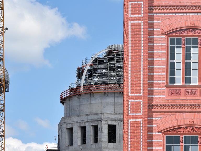 Die Kuppel des Rohbaus des Berliner Schlosses (l), das den Namen Humboldt-Forum trägt, ist am 09.06.2015 in Berlin am Schinkelplatz neben der Schaufassade der Schinkelschen Bauakademie zu sehen.