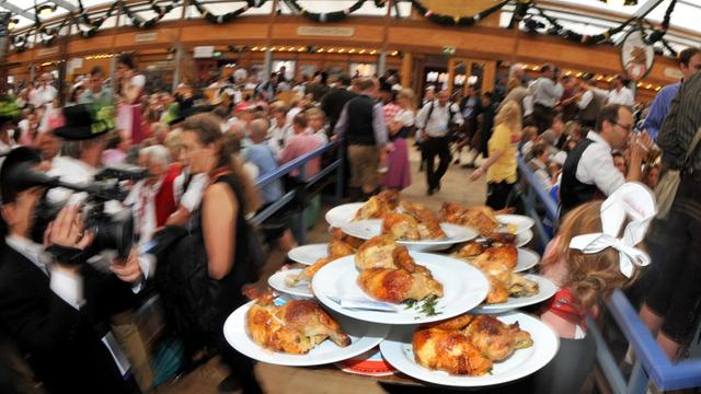 Eine Kellnerin bringt am 22.09.2012 beim 179. Münchner Oktoberfest auf der Theresienwiese in München (Bayern) gebratene Hendl (Hähnchen) zu den Gästen.