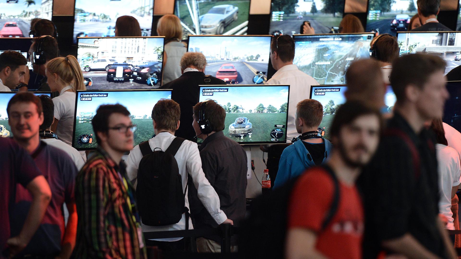 Besucher spielen am 13.08.2014 in Köln (Nordrhein-Westfalen) am Fachbesuchertag der Computerspielemesse "Gamescom" das Spiels "The Crew". Besucher spielen am 13.08.2014 in Köln (Nordrhein-Westfalen) am Fachbesuchertag der Computerspielemesse "Gamescom" das Spiels "The Crew".