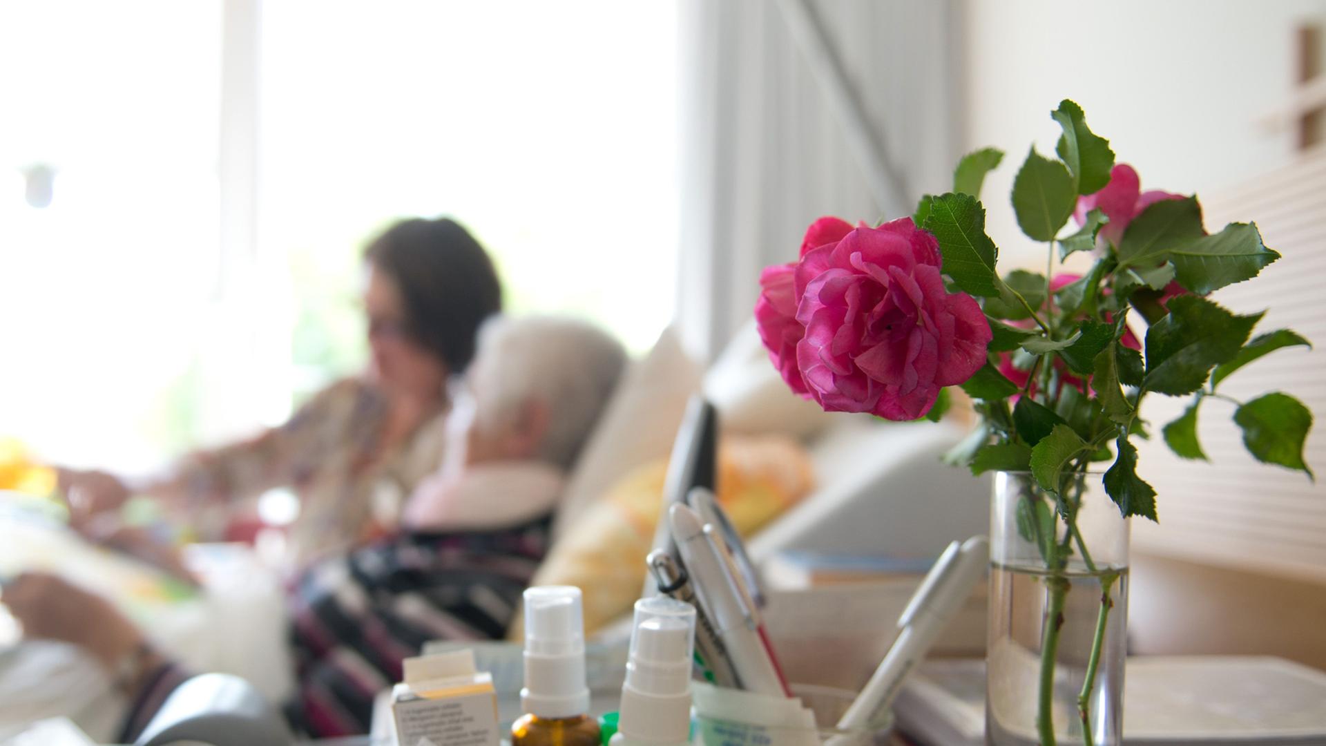 Eine Kunsttherapeutin zeichnet mit einer Frau in einem Hospiz ein Bild. Eine Kunsttherapeutin zeichnet mit einer Frau in einem Hospiz ein Bild.