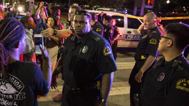 Nach der Festnahme eines Verdächtigen versuchen Polizisten in Dallas die Menschen zu beruhigen. Zuvor waren vier Beamte bei Protesten gegen Polizeigewalt erschossen worden.