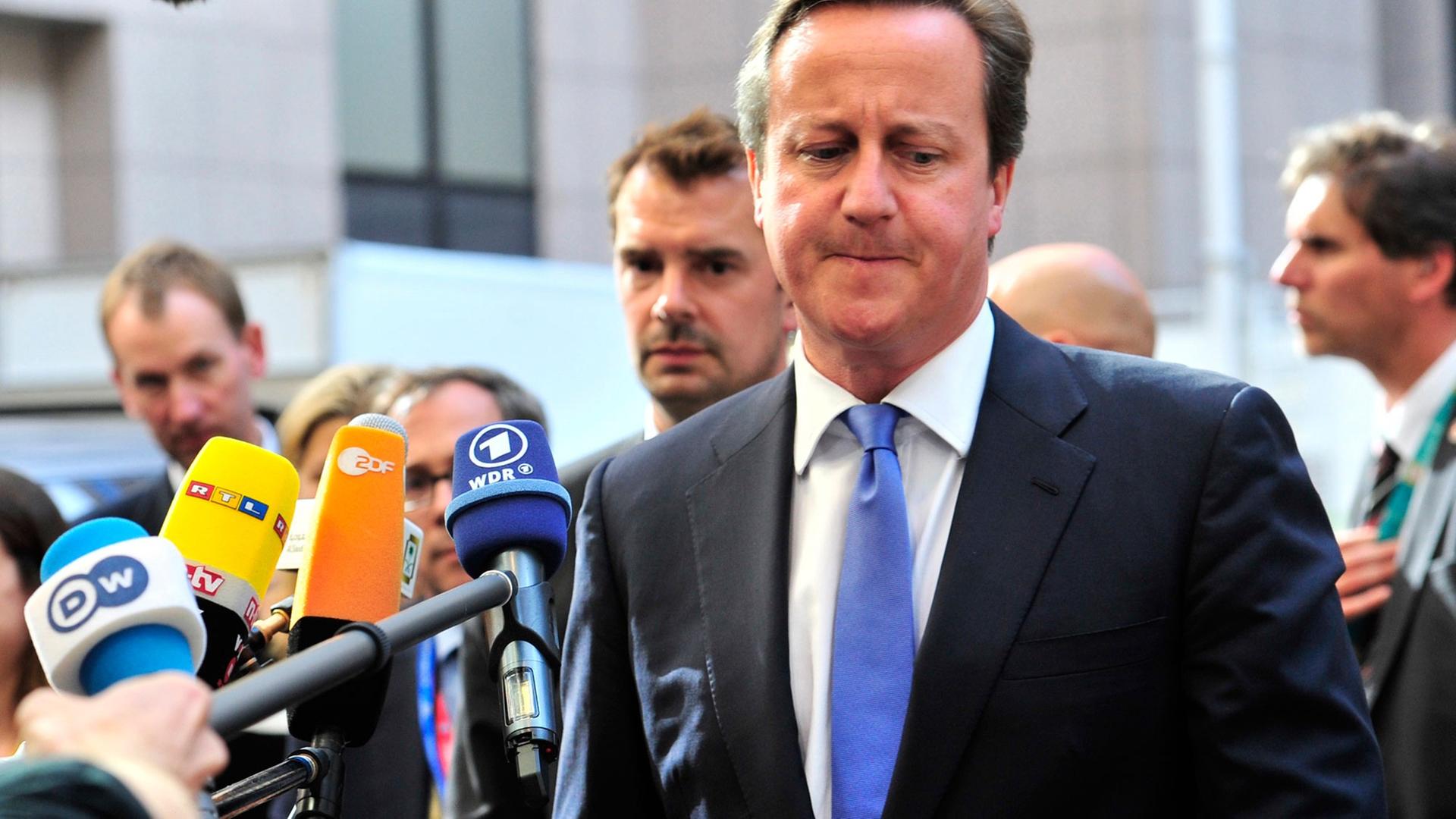 Der britische Premierminister David Cameron beim Gang in die Zentrale der Europäischen in Union in Brüssel, Pressevertreter halten ihm Mikrofone hin. Der britische Premierminister David Cameron beim Gang in die Zentrale der Europäischen in Union in Brüssel, Pressevertreter halten ihm Mikrofone hin.