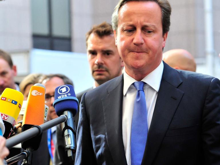 Der britische Premierminister David Cameron beim Gang in die Zentrale der Europäischen in Union in Brüssel, Pressevertreter halten ihm Mikrofone hin.