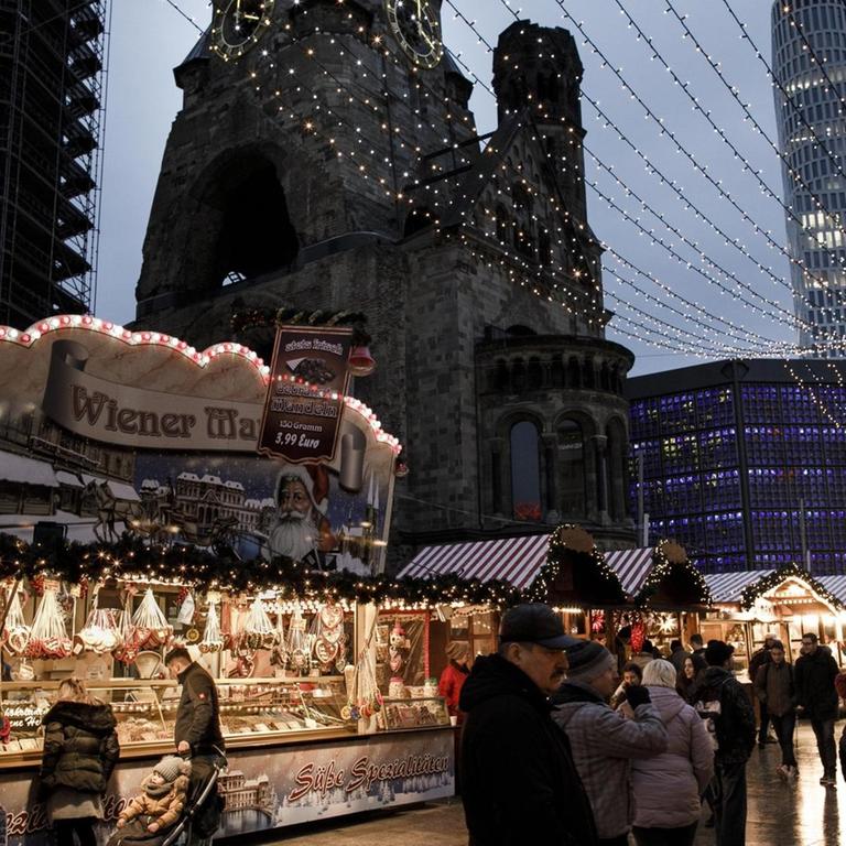 Besucher gehen über den Weihnachtsmarkt am Breitscheidplatz. 