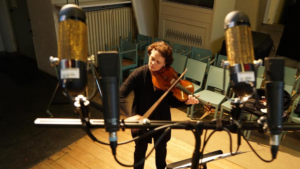 Die Musikerin ist zwischen etlichen Mikrophonen zu sehen. Die Musikerin ist zwischen etlichen Mikrophonen zu sehen.