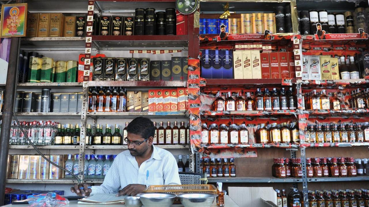 Ein Verkäufer in einem Alkoholgeschäft in Indien.