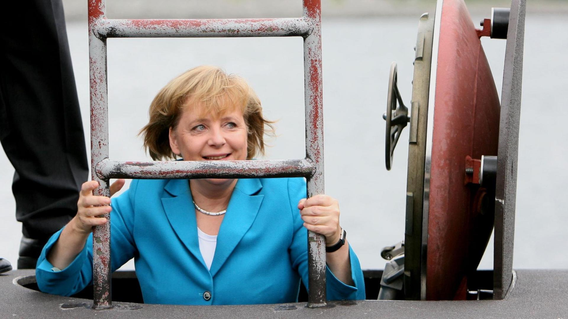 Bundeskanzlerin Angela Merkel (CDU) steigt am 31.08.2006 bei ihrem Besuch der Marine in Rostock-Warnemünde durch eine Luke in das U-Boot des neuen Typs 212 A. Nach der Besichtigung des U-Boots startet sie zu einer mehrstündige Fahrt an Bord der Fregatte «Sachsen». Merkel will sich nach Angaben der Marine über den Einsatzausbildungsverband der Flotte informieren, der derzeit mit zwei Fregatten, sechs Schnellbooten, zwei Minen-Jagdbooten und einem U-Boot sein jährliches Manöver in der Ostsee abhält. Foto: Jens Büttner +++(c) dpa - Report+++ Bundeskanzlerin Angela Merkel (CDU) steigt am 31.08.2006 bei ihrem Besuch der Marine in Rostock-Warnemünde durch eine Luke in das U-Boot des neuen Typs 212 A. Nach der Besichtigung des U-Boots startet sie zu einer mehrstündige Fahrt an Bord der Fregatte «Sachsen». Merkel will sich nach Angaben der Marine über den Einsatzausbildungsverband der Flotte informieren, der derzeit mit zwei Fregatten, sechs Schnellbooten, zwei Minen-Jagdbooten und einem U-Boot sein jährliches Manöver in der Ostsee abhält. Foto: Jens Büttner +++(c) dpa - Report+++