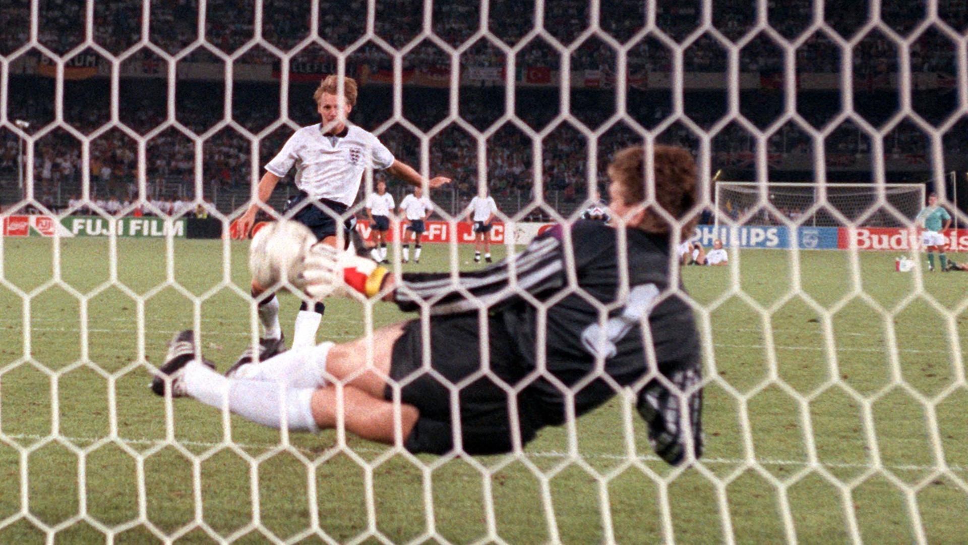 Torhüter Bodo Illgner (vorn) pariert den vom englischen Abwehrspieler Stuart Pearce getretenen Elfmeter. Damit ist die deutsche Fußballnationalmannschaft beim Stand von 3:3 im Elfmeterschießen mit England im Vorteil. Sie gewinnt am 04.07.1990 im Turiner Stadion delle Alpi das Halbfinalspiel der Fußball-WM am Ende mit 4:3. Nach der Verlängerung hatte es 1:1 gestanden.