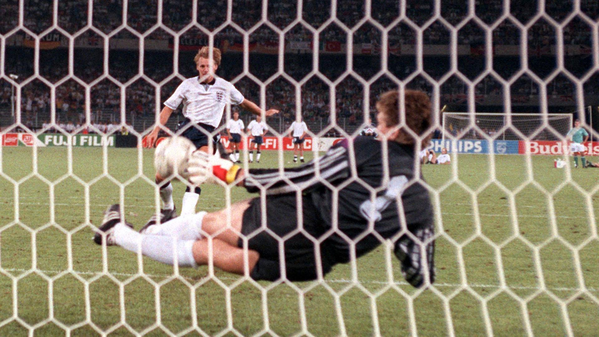 Torhüter Bodo Illgner (vorn) pariert den vom englischen Abwehrspieler Stuart Pearce getretenen Elfmeter. Damit ist die deutsche Fußballnationalmannschaft beim Stand von 3:3 im Elfmeterschießen mit England im Vorteil. Sie gewinnt am 04.07.1990 im Turiner Stadion delle Alpi das Halbfinalspiel der Fußball-WM am Ende mit 4:3. Nach der Verlängerung hatte es 1:1 gestanden. Torhüter Bodo Illgner (vorn) pariert den vom englischen Abwehrspieler Stuart Pearce getretenen Elfmeter. Damit ist die deutsche Fußballnationalmannschaft beim Stand von 3:3 im Elfmeterschießen mit England im Vorteil. Sie gewinnt am 04.07.1990 im Turiner Stadion delle Alpi das Halbfinalspiel der Fußball-WM am Ende mit 4:3. Nach der Verlängerung hatte es 1:1 gestanden.