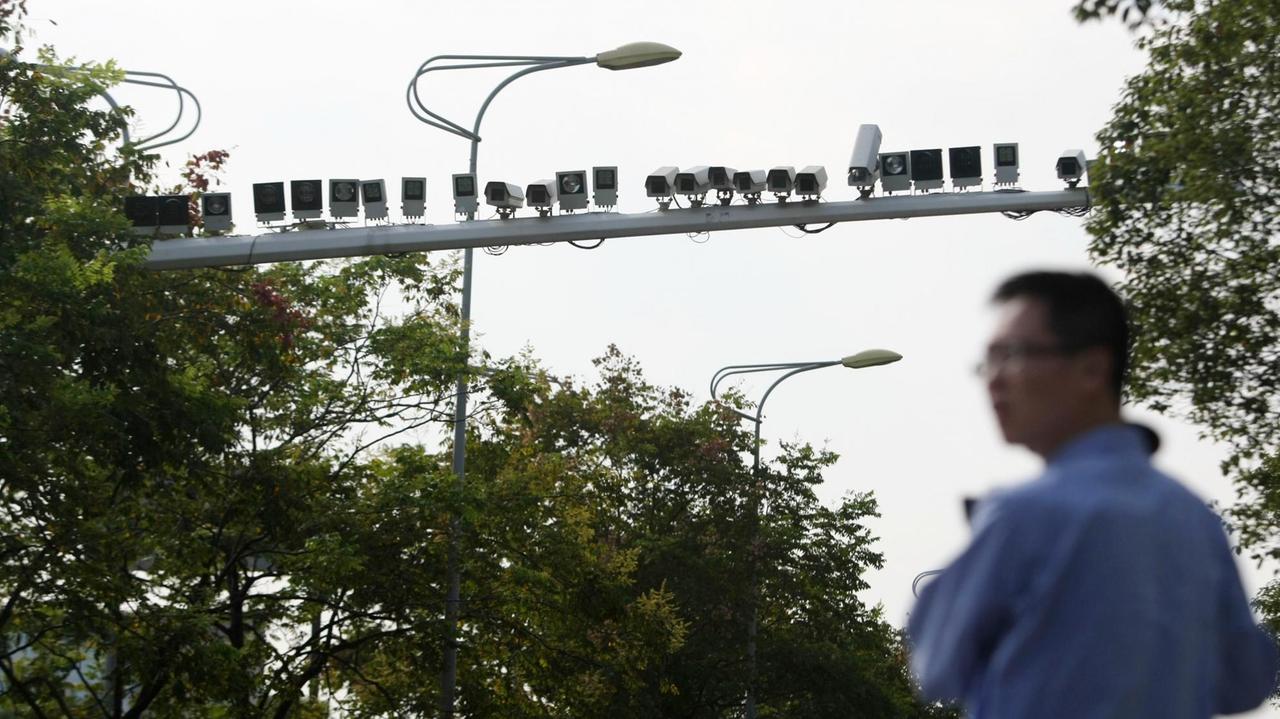Dutzende Überwachungskameras über einer Straße in Shanghai.