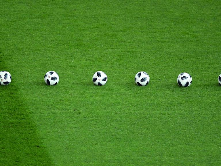 Sechs Fußbälle liegen beim Testspiel Deutschland - Brasilien im Berliner Olympiastadion am 27.03.2018 in einer Reihe auf dem Rasen.