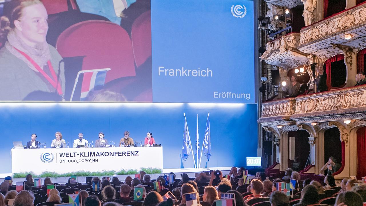 Auf einer Theaterbühne sitzen auf einem Podium verschiedene Umweltexperten: Florian Rauser, Satya Bhowmik, Schirin Fahti, Kenneth Gbandi, Sabine Hain, Bernd Hezel und Ana Soliz Landivar Stange (l-r) agieren am 18.11.2014 in Hamburg auf der Fotoprobe von "Welt-Klimakonferenz". Foto: Markus Scholz Auf einer Theaterbühne sitzen auf einem Podium verschiedene Umweltexperten: Florian Rauser, Satya Bhowmik, Schirin Fahti, Kenneth Gbandi, Sabine Hain, Bernd Hezel und Ana Soliz Landivar Stange (l-r) agieren am 18.11.2014 in Hamburg auf der Fotoprobe von "Welt-Klimakonferenz". Foto: Markus Scholz