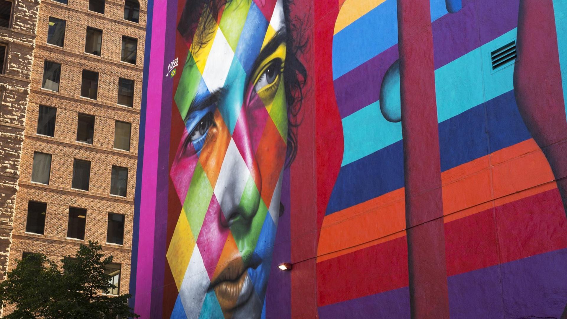 Ein buntes Gemälde an einer großen Gebäudewand in Minneapolis zeigt Bob Dylan und eine Gitarre. Ein buntes Gemälde an einer großen Gebäudewand in Minneapolis zeigt Bob Dylan und eine Gitarre.