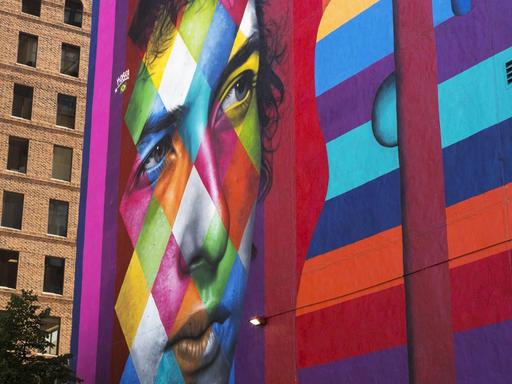 Ein buntes Gemälde an einer großen Gebäudewand in Minneapolis zeigt Bob Dylan und eine Gitarre.