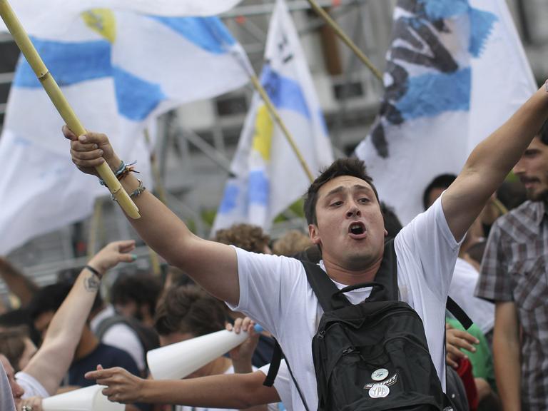 Eine Demo in Argentinien: Menschen schwenken die argentinische Fahne.