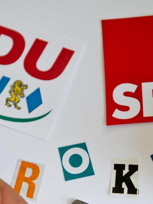 "GroKo" aus ausgeschnittenen Buchstaben zusammen mit den Logos der Parteien CDU/CSU und SPD